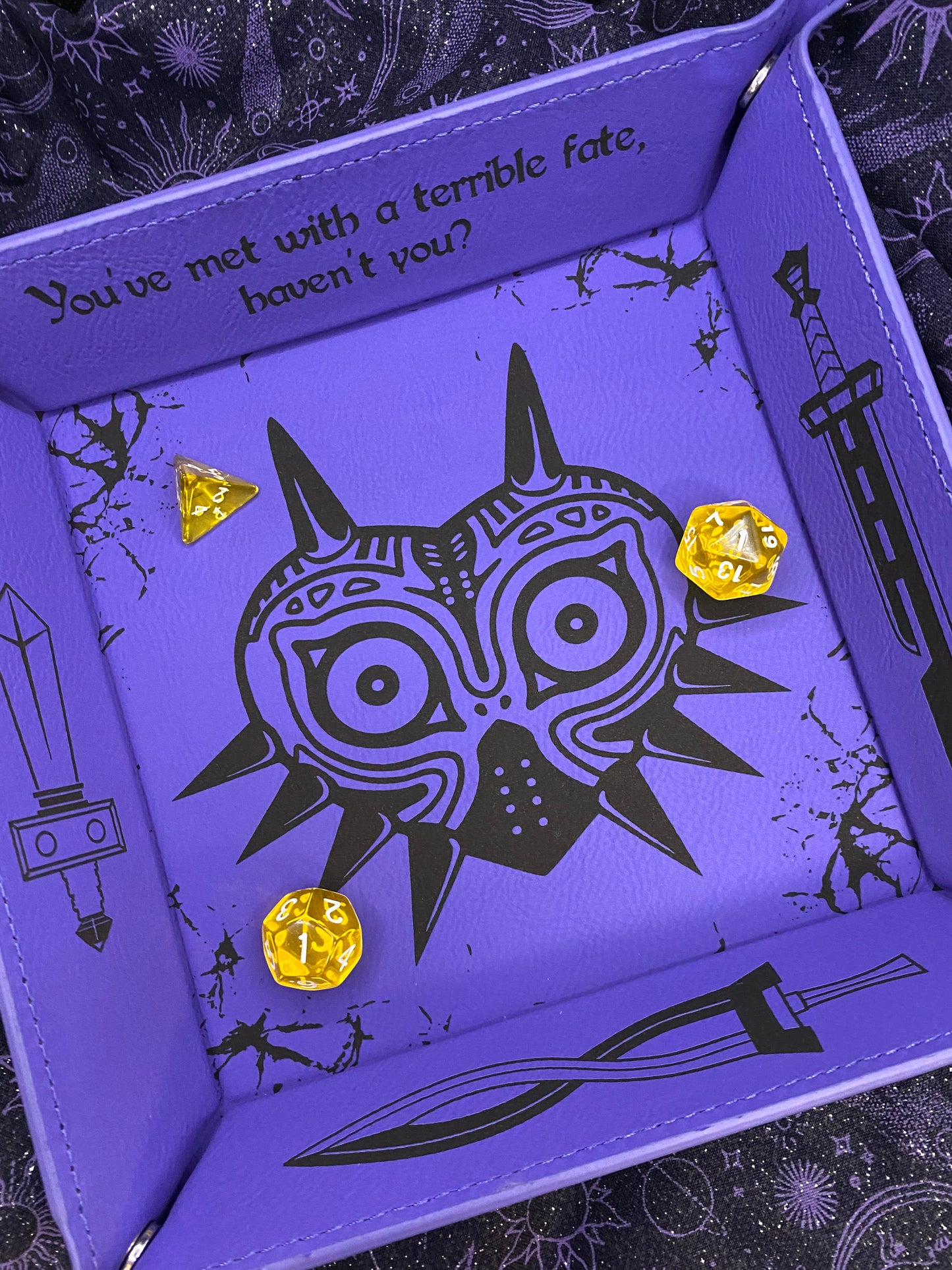 Purple leather dice tray featuring a laser engraved Majora’s Mask design and sword icons, inspired by The Legend of Zelda. Ideal for tabletop and D&D fans who love Zelda lore.