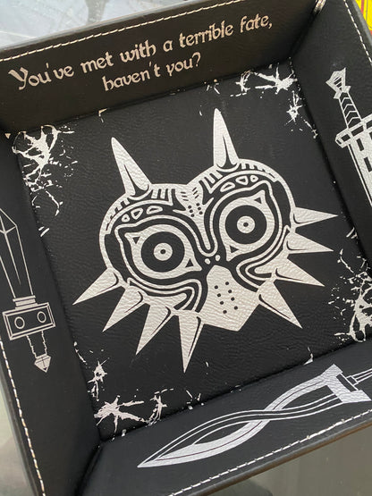 Black leather dice tray featuring a laser engraved Majora’s Mask design and sword icons, inspired by The Legend of Zelda. Ideal for tabletop and D&D fans who love Zelda lore.