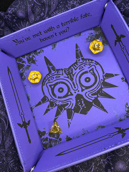 Purple leather dice tray featuring a laser engraved Majora’s Mask design and sword icons, inspired by The Legend of Zelda. Ideal for tabletop and D&D fans who love Zelda lore. Slight misprint with the master swords